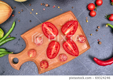 chopped tomato on a wooden board with vegetables one 69324246