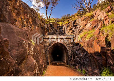 Old mountain tunnel surrounded by rocks Old mountain tunnel surrounded by rocks 69326025