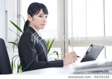 日本女性商業女性，在辦公室使用平板電腦將紙質材料轉換為數據 69326188