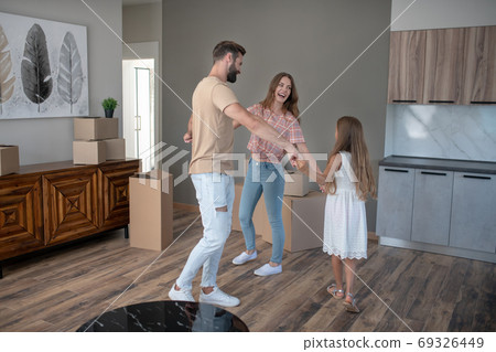 Parents and daughter dancing and looking happy 69326449