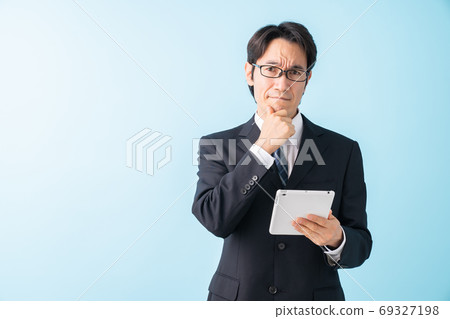 Look at the tablet Middle male business thinking 69327198