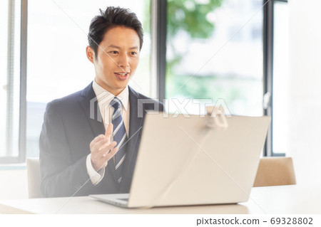 A man making a video call to a PC 69328802