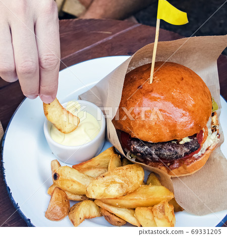 Delicious burger with french frieson the wooden table Delicious burger with french frieson the wooden table 69331205