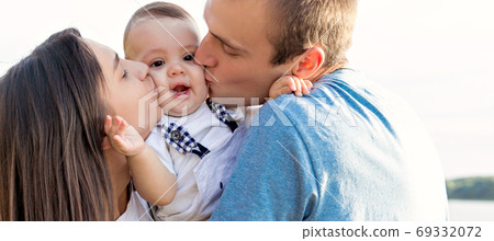 Mom and dad kiss their baby. Mom and dad kiss their baby. 69332072