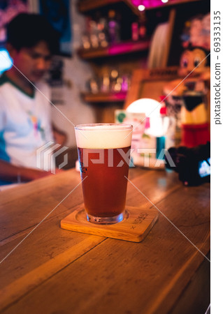 Beer poured into glasses in the bar at night. 69333135