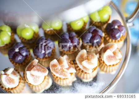 Bite-sized fruit tart on a cake stand Bite-sized fruit tart on a cake stand 69333165