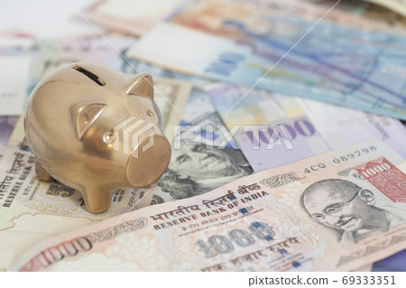 Golden piggy bank with International currencies 69333351