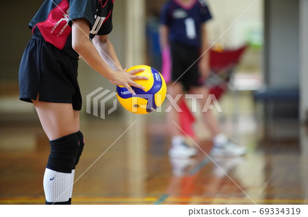 Volleyball player trying to hit a serve 69334319