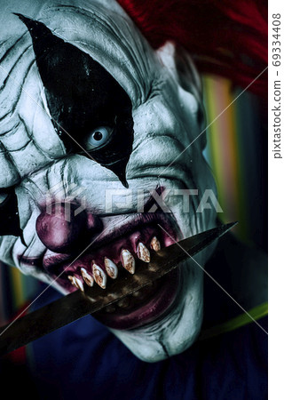 scary evil clown with a big knife in his mouth scary evil clown with a big knife in his mouth 69334408