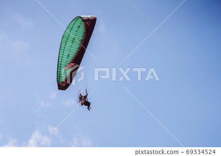 paramotor flying on blue sky 69334524