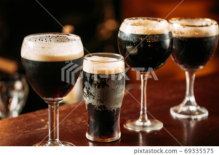 Side view on differend glasses with dark beer Side view on differend glasses with dark beer 69335575
