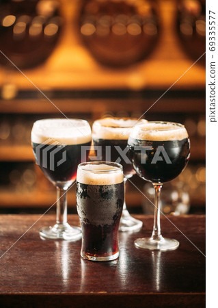 Side view on differend glasses with dark beer Side view on differend glasses with dark beer 69335577