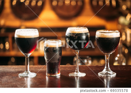 Side view on differend glasses with dark beer Side view on differend glasses with dark beer 69335578