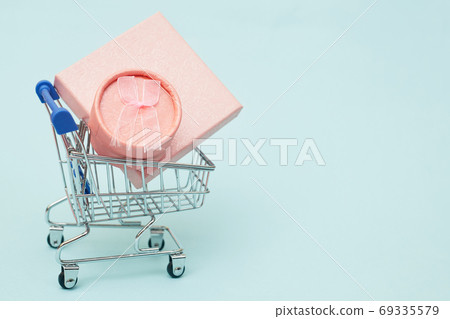 black friday concept, gift boxes with shopping trolley on blue pastel background, copy space black friday concept, gift boxes with shopping trolley on blue pastel background, copy space 69335579