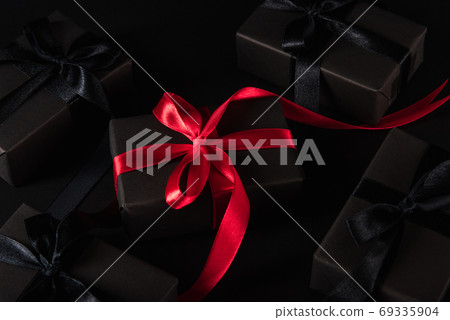 gift box wrapped black paper and black bow ribbon present around 69335904