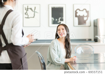 A young woman and a clerk ordering at a cafe 69337151