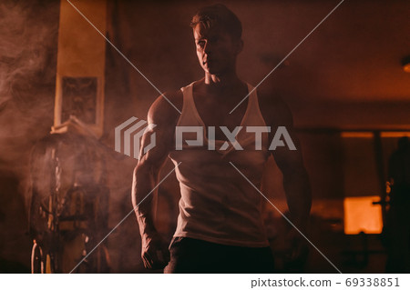 Powerful Muscular man posing in darkness 69338851
