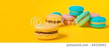 Sweet almond colorful unicorn pink blue yellow green macaron or macaroon dessert cake isolated on trendy yellow modern fashion background. French sweet cookie. Minimal food bakery concept Copy space Sweet almond colorful unicorn pink blue yellow green macaron or macaroon dessert cake isolated on trendy yellow modern fashion background. French sweet cookie. Minimal food bakery concept Copy space 69338941