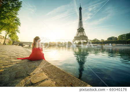 Young woman in red, looking to Eiffel tower, Paris Young woman in red, looking to Eiffel tower, Paris 69340176