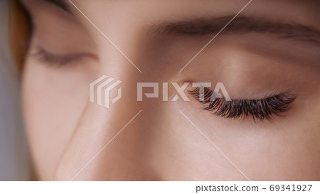 Eyelash Extension Procedure. Woman Eye with Long Eyelashes. Close up, selective focus. Eyelash Extension Procedure. Woman Eye with Long Eyelashes. Close up, selective focus. 69341927