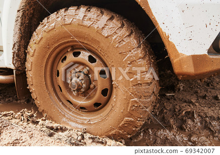 Wheel closeup in a countryside landscape with a muddy road. Wheel closeup in a countryside landscape with a muddy road. 69342007