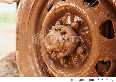 Wheel closeup in a countryside landscape with a muddy road. Wheel closeup in a countryside landscape with a muddy road. 69342009