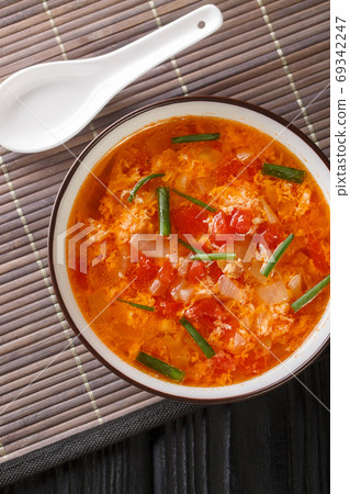 Chinese tomato egg drops soup close-up in a bowl. Vertical top v 69342247