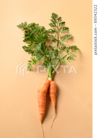 Ugly fresh carrot on beige. organic vegetables. Ugly fresh carrot on beige. organic vegetables. 69342322