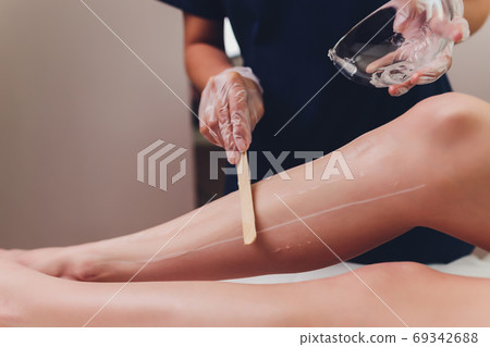 Beautician Giving Epilation Laser Treatment To Woman On Thigh. Beautician Giving Epilation Laser Treatment To Woman On Thigh. 69342688