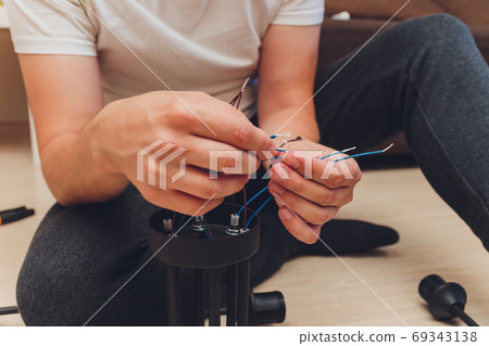Chandelier with wires and tools on the floor, preparation to installation. Chandelier with wires and tools on the floor, preparation to installation. 69343138