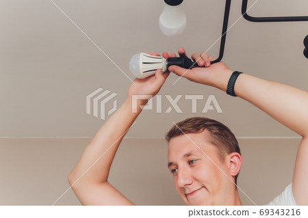 an electrician. repair work. Chandelier to hang on the ceiling. an electrician. repair work. Chandelier to hang on the ceiling. 69343216