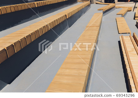 Modern minimalistic benches stairs in a city park after the rain. Modern minimalistic benches stairs in a city park after the rain. 69343296