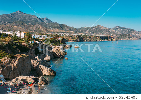 Nerja In Spain. People Resting On Beach Calahonda, Coast Near Resort Town Of Nerja In Spain. Elevated View From Balcon De Europa. Playa Calahonda 69343405