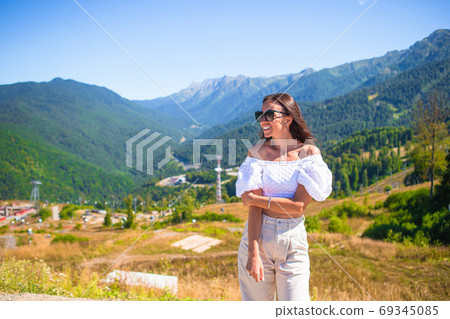 Beautiful happy young woman in mountains in the background of fog Beautiful happy young woman in mountains in the background of fog 69345085