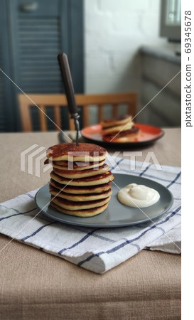 Plate with stack of homemade pancakes and sour cream on wooden table, selective focus 69345678