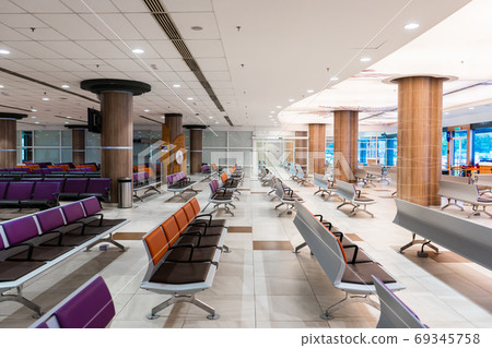 Empty international airport building during pandemic. Empty seat rows at airport lounge. 69345758