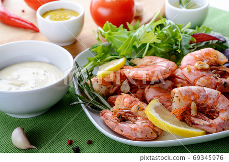 Prawns Shrimps cooked with garlic and rosemary, served on white plate. 69345976