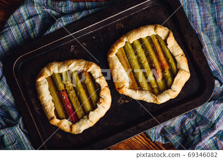 Two rhubarb mini galettes on baking sheet Two rhubarb mini galettes on baking sheet 69346082