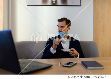 Portrait of young handsome businessman with face mask in quarantine of flu. 69346230