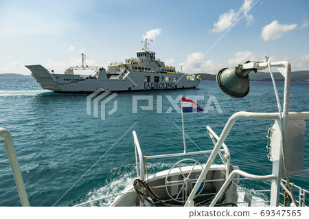 Ferry sailing between Orebic and Korcula island.  69347565
