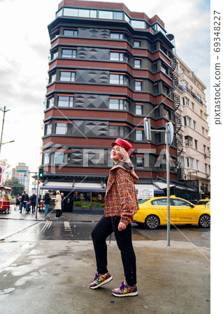 a blonde girl in a cap stands on the street a blonde girl in a cap stands on the street 69348227