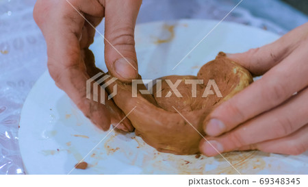 Professional male potter making mug in pottery workshop Professional male potter making mug in pottery workshop 69348345