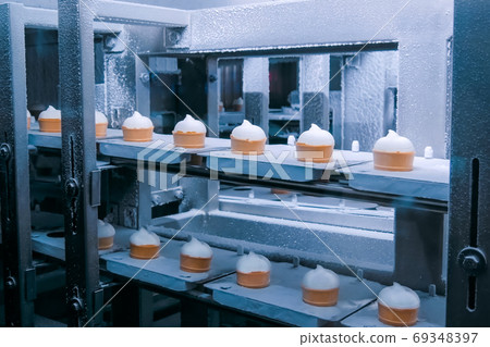 Automated technology concept - conveyor belt with icecream cones at food factory Automated technology concept - conveyor belt with icecream cones at food factory 69348397