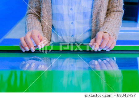 Woman using interactive touchscreen display at technology exhibition Woman using interactive touchscreen display at technology exhibition 69348457