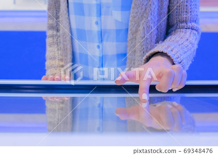 Woman using interactive touchscreen display at technology exhibition Woman using interactive touchscreen display at technology exhibition 69348476