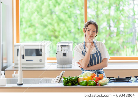 Woman thinking in the kitchen Woman thinking in the kitchen 69348804