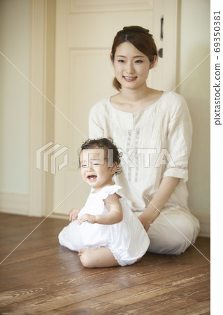 Parent and child playing in the living room 69350381