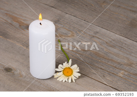 burning white candle and camomile flower 69352193