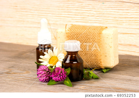 chamomile and clover handmade soap and essential oil in small bottle 69352253