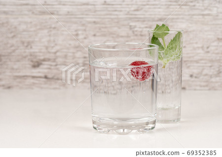 strong alcohol drink with mint and raspberry in high glass 69352385